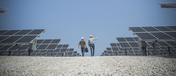 technicians talking near solar panels