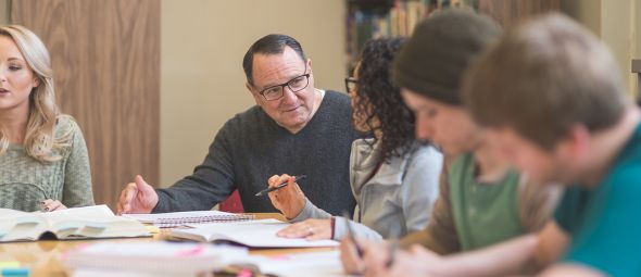 College students study together around a table in the library