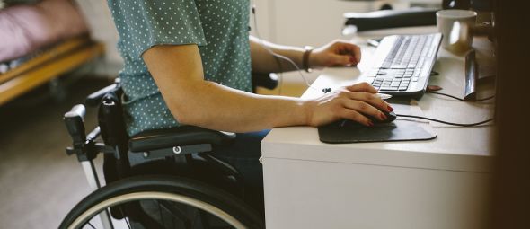 Midsection of young disabled woman using computer at home