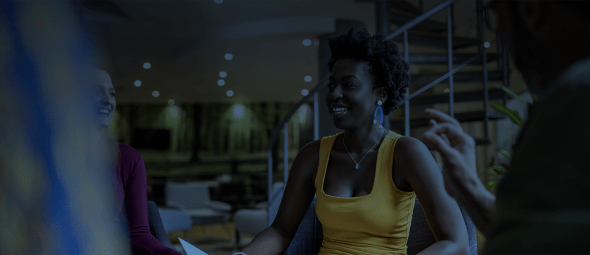 North african woman smiling, sitting in candid south african diverse business meeting